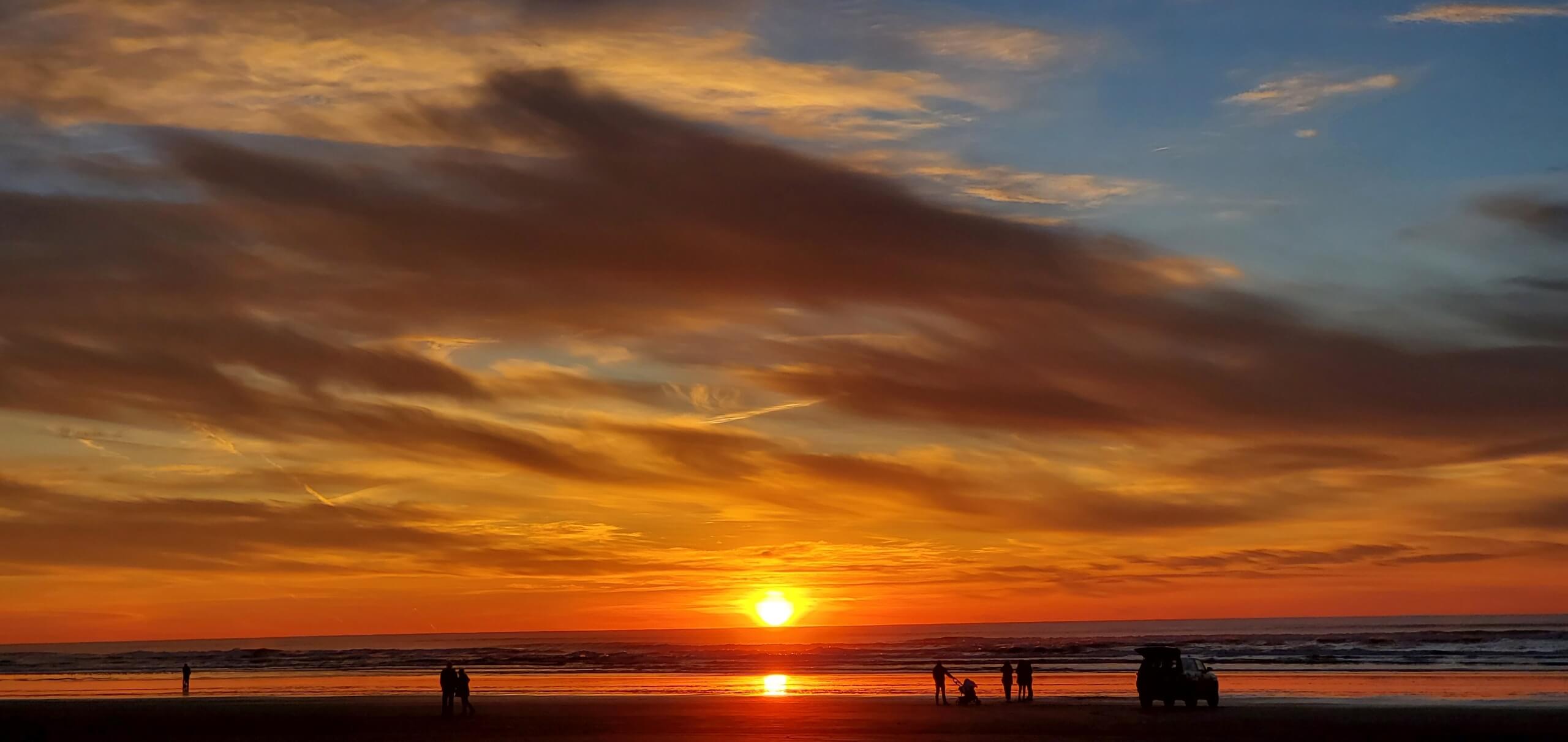 A picture of the sunset in Ocean Shores with some people in the foreground.